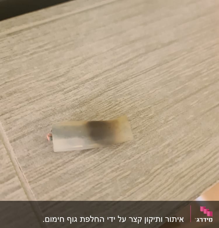 חוט חשמל עם בידוד שרוף על שולחן עץ